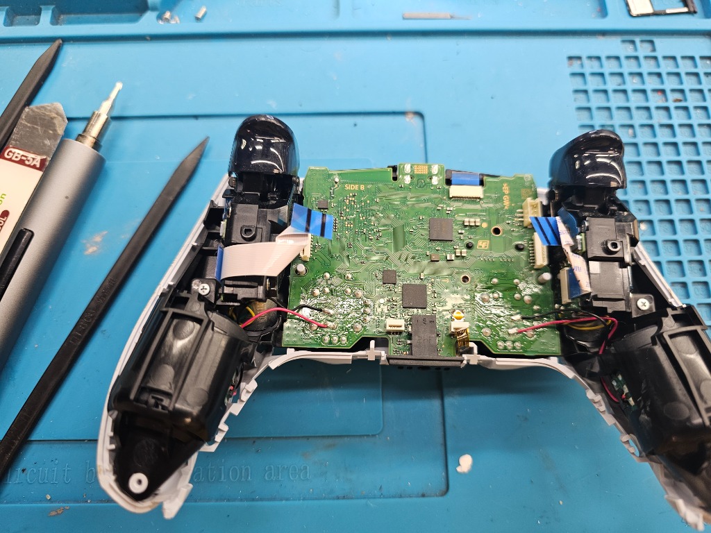 Réparation et micro-soudure de manette PS5 DualSense en atelier à Longueuil